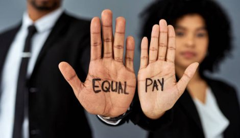 Shot of a businessman and businesswoman advocating for equal pay against a grey studio background