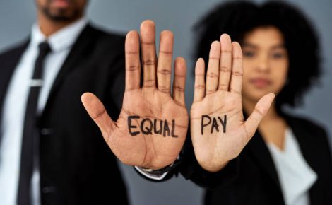 Shot of a businessman and businesswoman advocating for equal pay against a grey studio background
